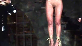 Blonde Girl Has Weights Attached to Her Feet and Is Hoisted up for Whipping