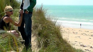 Slender blonde milf gives a wonderful handjob on the beach